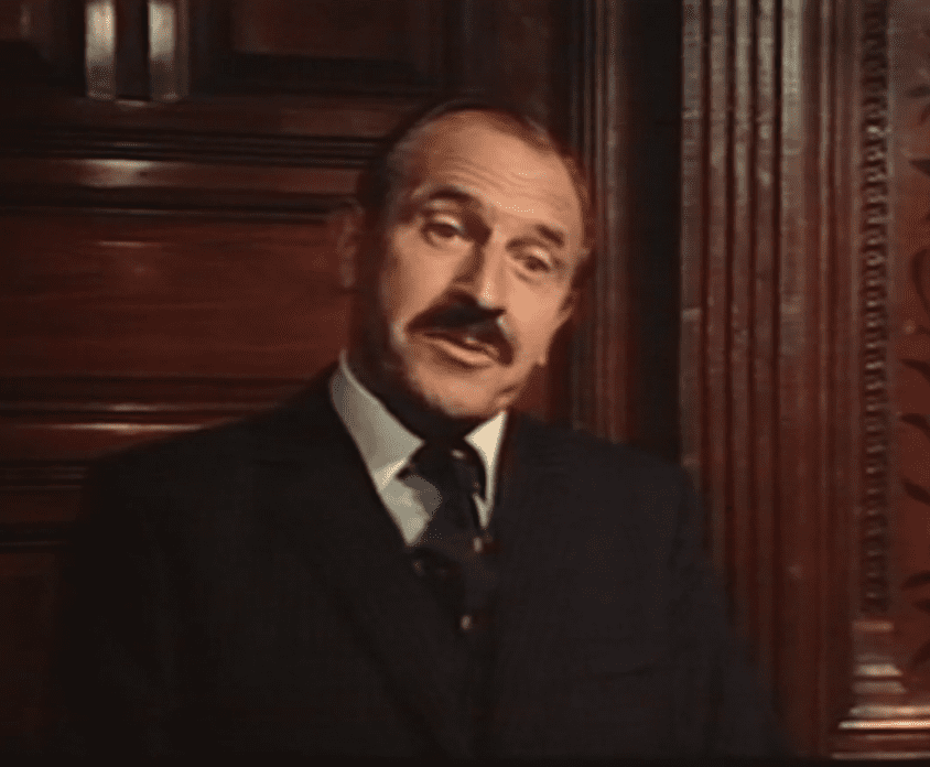 A black and white portrait of a young Leonard Rossiter.